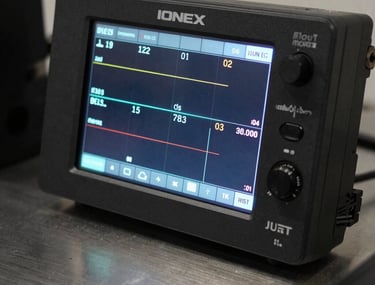 The digital interface of the IONEX controller showing clear, precise readings. The screen glow is reflected on a metallic surface.