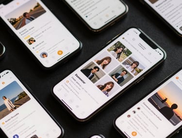 A collection of sleek mobile devices arranged on a dark surface, each displaying a different section of a cohesive UI system, East Asian / Japanese aesthetic.