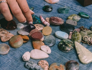 mano de persona seleccionando piedras naturales como amatista, ojo de tigre