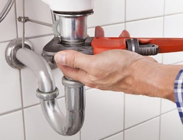 Suasana Plumbing services installing new sink pipes and fixing leaks.