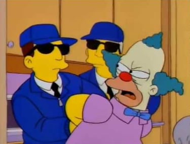 a cartoon character dressed as a clown in a suit and sunglasses