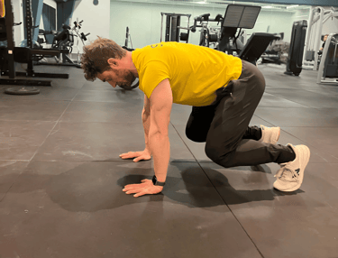 a man in a yellow shirt is doing a push up