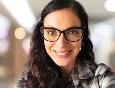 a woman with glasses and a plaid shirt