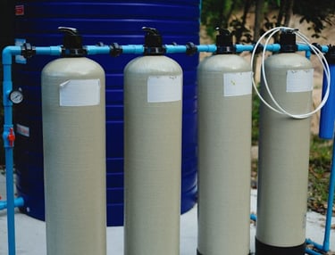 Four pressure tanks connected to water line.
