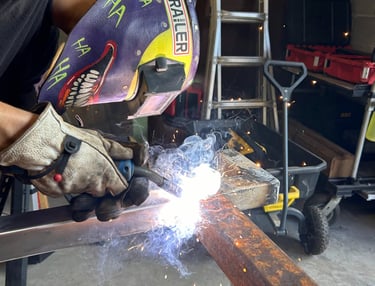 a man welding a beam of steel