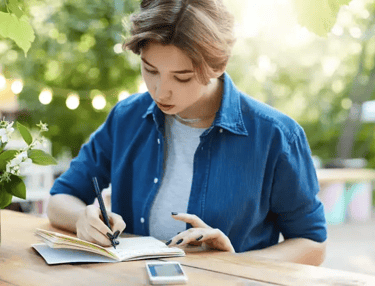 Pessoa treinando frases assertivas em um caderno