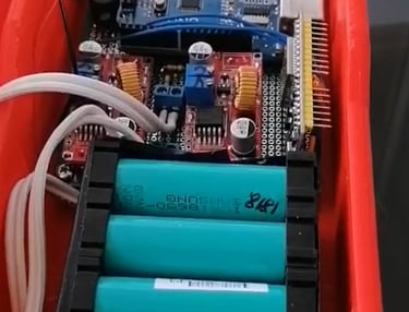 Internal view of an Arduino microcontroller project with gas sensors and 18650 lithium batteries in a red 3D printed case.