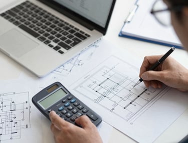 Engineers collaborating on an electrical system blueprint in an office.