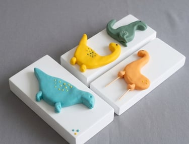 Dinosaurios en fondant modelados a mano por Cocina con Ely, diseñados para la decoración de tortas i