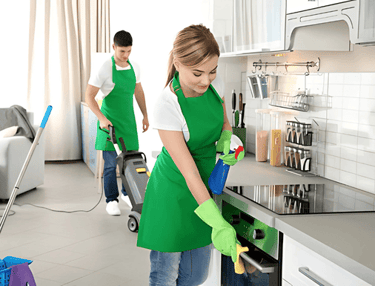 a man and woman cleaning a kitchen counter