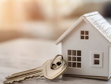 a table with house keys next to a model house