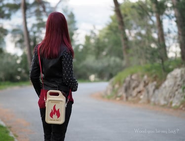 a woman with red hair and a wooden handbag walking down a road