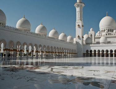 Las cúpulas y arcos de mármol blanco de la Gran Mezquita Sheikh Zayed en Abu Dabi, bajo un cielo azu