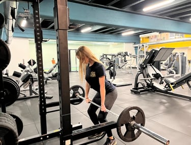 Istruttrice della palestra Move 2 Grow a Milano esegue esercizi di sollevamento pesi in un'area attrezzata per allenamento.