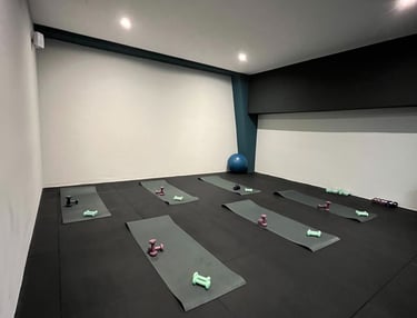 Sala fitness della palestra Move 2 Grow a Milano con tappetini, manubri e attrezzature per allenamenti di gruppo.