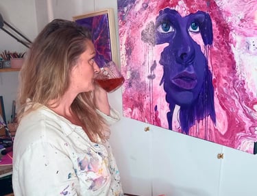 l'artiste peintre Yziya admire une de ses œuvres.