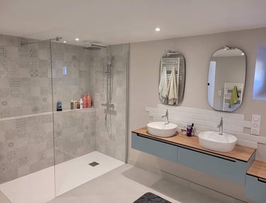Une très grande salle de bains avec une grande espace douche, baignoire double, WC et jolis meubles
