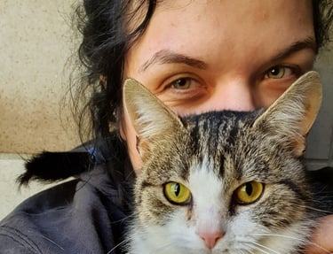 eine Frau mit einer Katze auf dem Schoß