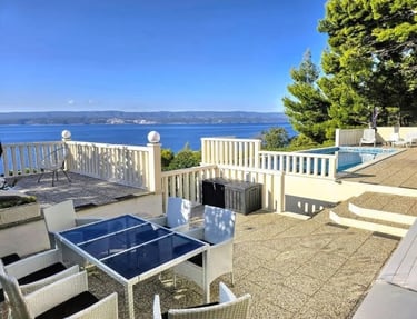The photo depicts the courtard dining set as well as parts of the eastern sun terrace and pool.