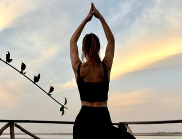 Pose de yoga avec vue sur le bolong et le début de la mangrove depuis le boutique hôtel Maison Fimela situé au coeur du Sine
