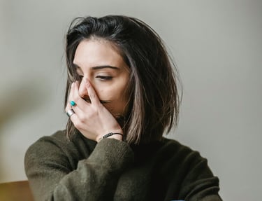 femme dont le visage et la posture indique une difficulté émotionnelle