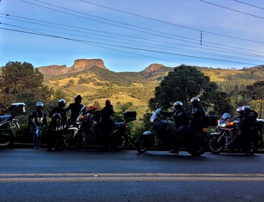 Pessoas de moto em frente à Pedra do Baú em São Bento do Sapucaí