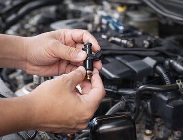 bico injetor de combustível sendo segurado durante manutenção no motor