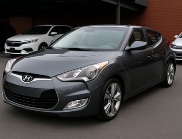 Hyundai Veloster cinza visto de frente e lateral em estacionamento, destaque esportivo