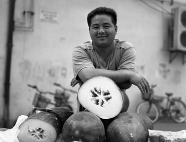 Man in Shanghai selling winter melons at a market