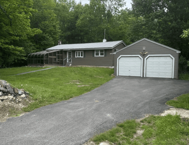 a client's house with a driveway and garage with a garage door
