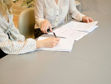 Two ladies are signing documents