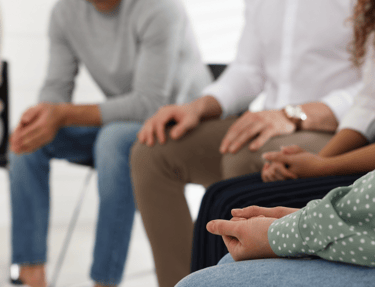 un groupe de personnes assises en cercle sur des chaises pendant une pratique de méditation