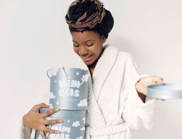 Fotografía de una mujer sujetando entre las manos una de las cajas del packaging de la marca Nimbus Cozy dreams