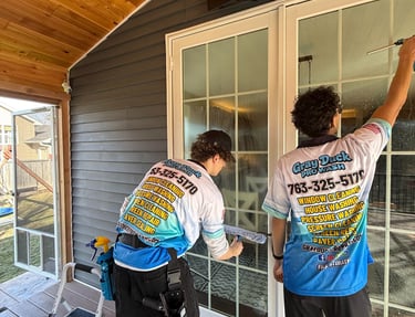 Two Gray Duck Pro Wash employees performing professional window cleaning using mop and squeegee on a