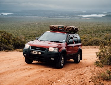 a red car with a large luggage bag on top of it