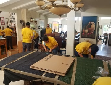 white glove movers in big win team carefully packing furniture and boxes in a residential home.