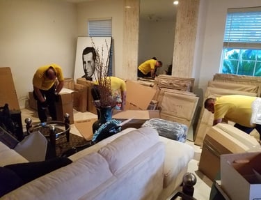 Professional movers in Big Win packing household furniture and boxes in a living room. artwork