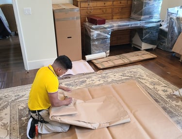 Professional mover big win carefully packing items with brown paper for a residential relocation.