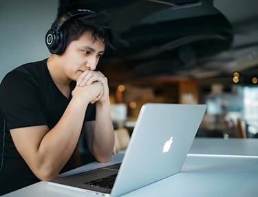 Student focusing on SAT prep with laptop and headphones, highlighting Admit 360's online SAT test