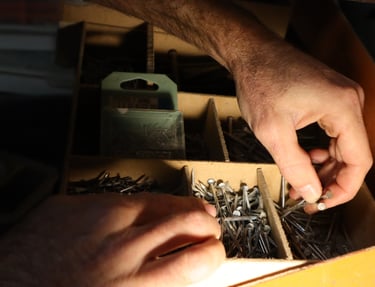 artisan qui prend des pointes dans son atelier pour faire de la charpente
