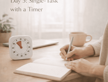 A visual timer on a desk next to a person writing in a notebook to practice single-tasking productivity.