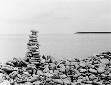 A monochrome image of a pile of stones on a stony beach