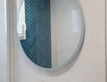 Miroir rond au dessus un meuble avec vasque poser et robinetterie couleur or
