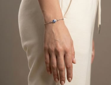 a woman's hand holding a bracelet with a evil eye