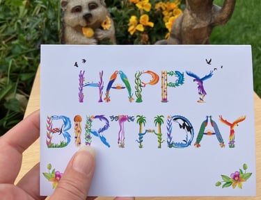 A greeting card with the words Happy Birthday printed in tropical exotic word art