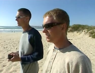 deux surfeurs australiens commentant les vagues sur une plage du Portugal 