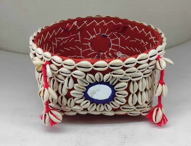 "Decorative bamboo basket wrapped in red fabric with shell embellishments and floral garland–Meant for export"
