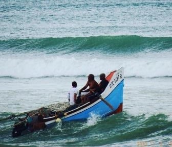 a group of people in a boat on a wave