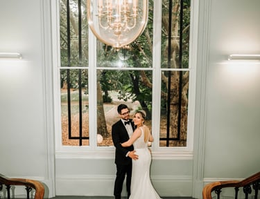 Romantic moment of a bride and groom posing on a grand staircase for their wedding photos