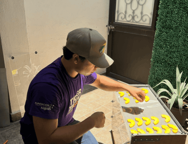 Cofundador de snacktein haciendo pruebas deshidratando rebanadas de piña en el sol